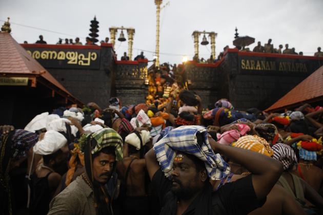 Devotees climb over the holy eighteen golden steps to worship diety of Hindu god Ayyapa at a temple premises in Sabarimala.(HT file photo)