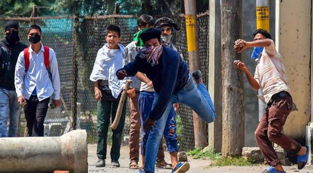 Students throw stones at the police during a protest over arrest of the student Adil when he was entering the school, at Soura on the outskirts of Srinagar on Saturday.(PTI)