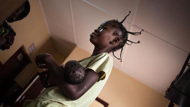 A mother waits with her child for the daily weight check. Nominally Christian militias emerged in response and France intervened militarily from 2013 to 2016 to push out the Seleka. Faustin-Archange Touadera was elected president and governs today, supported by a UN peacekeeping operation. But most of the country is controlled by ex-rebels and militias, acting as guardians for religious communities. (Florent Vergnes / AFP) A mother waits with her child for the daily weight check. Nominally Christian militias emerged in response and France intervened militarily from 2013 to 2016 to push out the Seleka. Faustin-Archange Touadera was elected president and governs today, supported by a UN peacekeeping operation. But most of the country is controlled by ex-rebels and militias, acting as guardians for religious communities. (Florent Vergnes / AFP)