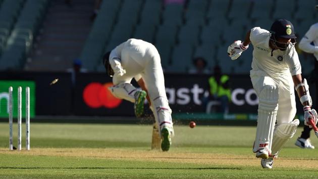 India's batsman Cheteshwar Pujara (L) is run out by a direct throw from Australian fieldsman Pat Cummins.(AFP)