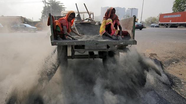 Labourers spread ash over newly constructed road tarmac to dry it and fill in the gaps, on the outskirts of Ahmedabad, Gujarat. (Amit Dave / REUTERS) Labourers spread ash over newly constructed road tarmac to dry it and fill in the gaps, on the outskirts of Ahmedabad, Gujarat. (Amit Dave / REUTERS)