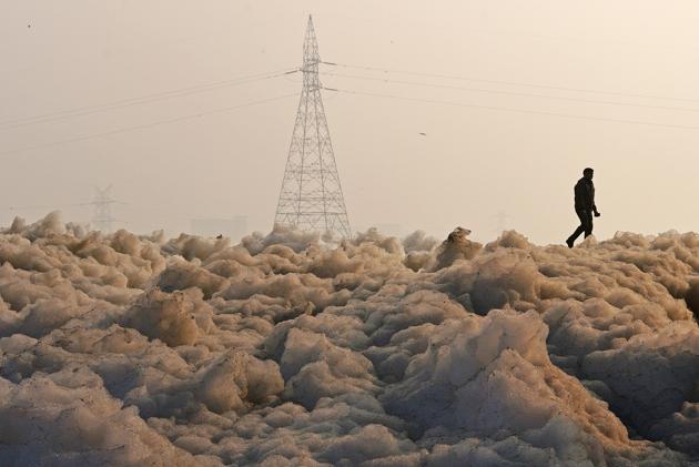 A man walks along a large amount of toxic industrial waste-foam that has become a common sight along the banks of the heavily polluted Yamuna river in New Delhi. (Biplov Bhuyan / HT Photo) A man walks along a large amount of toxic industrial waste-foam that has become a common sight along the banks of the heavily polluted Yamuna river in New Delhi. (Biplov Bhuyan / HT Photo)