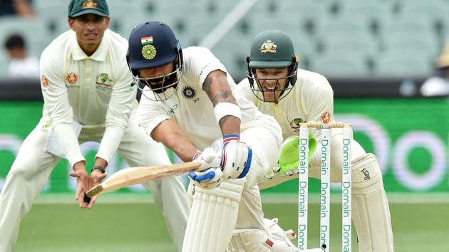 India vs Australia: India's captain Virat Kohli hits a ball as Australia's captain Tim Paine looks on during day three of the first Test.(AFP)