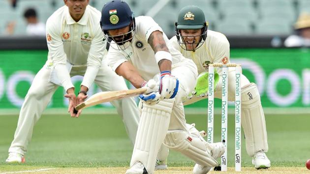 Virat Kohli (C) hits a ball watched by Australia's cricket captain Tim Paine (R).(AFP) Virat Kohli (C) hits a ball watched by Australia's cricket captain Tim Paine (R).(AFP)