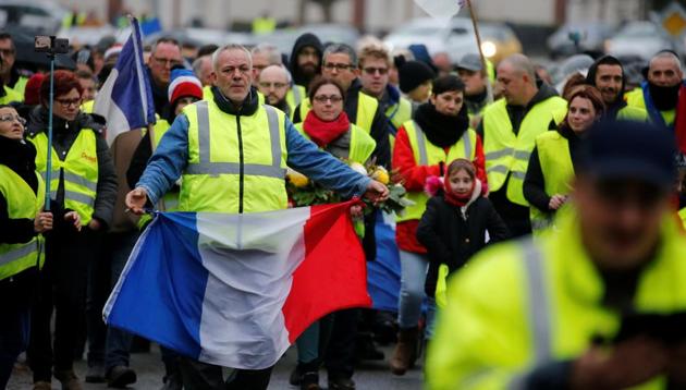 A protester wearing a yellow vest holds a French flag during a demonstration by the "yellow vests" movement in Somain, France, December 8, 2018.(Reuters Photo)