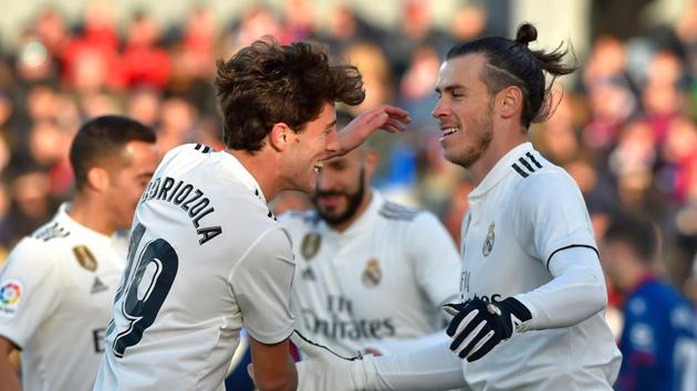 Real Madrid's Welsh forward Gareth Bale (R) is congratulated by teammate defender Alvaro Odriozola after scoring his team's first goal during the Spanish league football match between SD Huesca and Real Madrid CF at the El Alcoraz.(AFP)