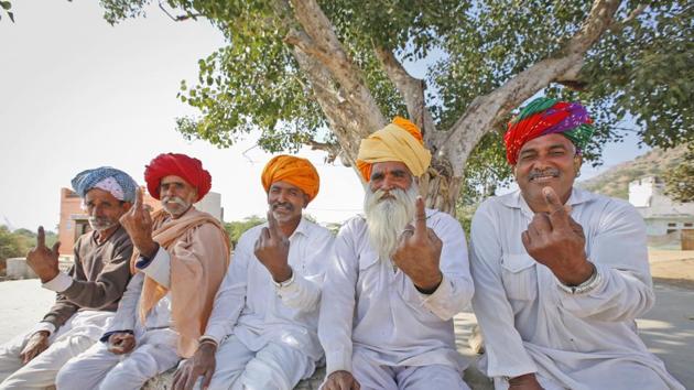 Rajasthan assembly elections 2018: Men show the indelible ink mark on their index fingers after casting their vote in village Padampura, near Ajmer.(AP Photo)