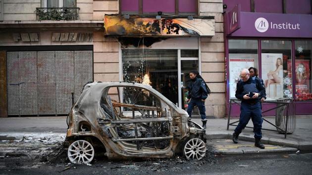 Police look at a burnt car in Beaubourg street in Paris, on December 9, 2018 a day after a ‘yellow vest’ protests as part of a fourth weekend of nationwide protests.(AFP Photo)