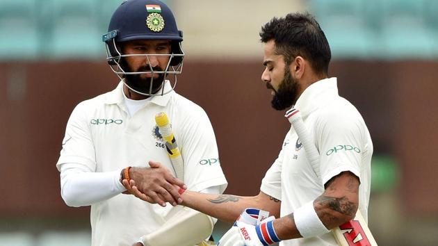 India's batsmen Virat Kohli (R) and Cheteshwar Pujara return to the pavilion for the lunch break on the second day.(AFP)