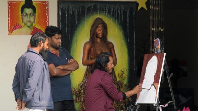 An inmate paints while others look on at his work in progress. The initiative aims to provide jail residents skills that can turn into vocations once they are released and also facilitate reformation while they serve their terms. (Parveen Kumar / HT Photo)