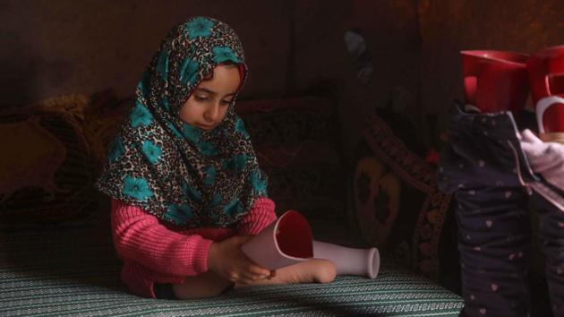 Originally from Aleppo region, Maya and her father Mohammed had to move to rebel-held Idlib province as fighting from Syria’s civil war began to rage around their home. Sitting on a foam mattress, his daughter unwrapped the artificial legs and attached them. (Aaref Watad / AFP) Originally from Aleppo region, Maya and her father Mohammed had to move to rebel-held Idlib province as fighting from Syria’s civil war began to rage around their home. Sitting on a foam mattress, his daughter unwrapped the artificial legs and attached them. (Aaref Watad / AFP)