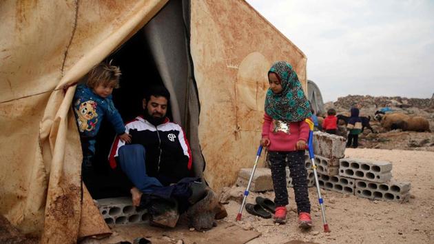 Maya Merhi stands with the support of crutches next to her disabled father (C) outside their tent. “I was so happy when I saw her walking,” Mohammed said. He suffers the same condition as his daughter, known as congenital amputation which means the person is born without lower limbs. (Aaref Watad / AFP) Maya Merhi stands with the support of crutches next to her disabled father (C) outside their tent. “I was so happy when I saw her walking,” Mohammed said. He suffers the same condition as his daughter, known as congenital amputation which means the person is born without lower limbs. (Aaref Watad / AFP)