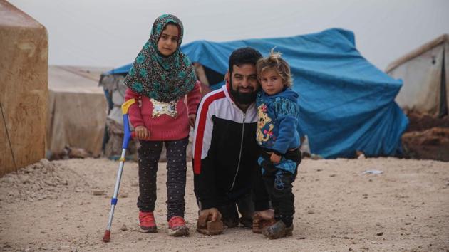 Merhi poses for a picture with the support of crutches next to her brother and father. Mohammed received prosthetic limbs as well, but admits that he isn’t yet as steady on them as his daughter. (Aaref Watad / AFP) Merhi poses for a picture with the support of crutches next to her brother and father. Mohammed received prosthetic limbs as well, but admits that he isn’t yet as steady on them as his daughter. (Aaref Watad / AFP)