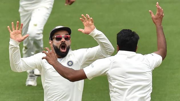 TOPSHOT - India's captain Virat Kohli (L) celebrates with spin bowler Ravichandran Ashwin (R) after beating Australia on day five of the first Test cricket match at the Adelaide Oval on December 10, 2018.(AFP)