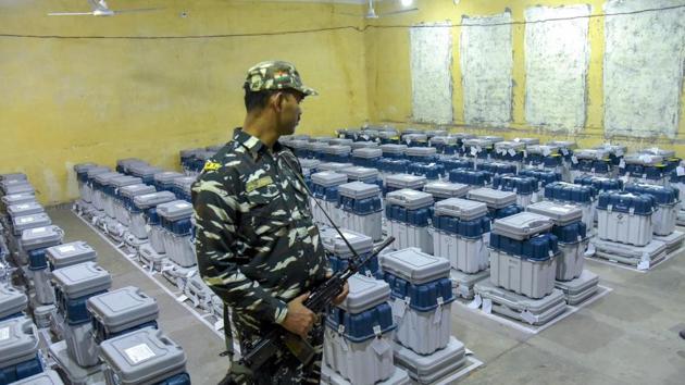 A para-military jawan guards EVMs (Electronic Voting Machines) at a counting centre in Jaipur on Tuesday.(PTI)