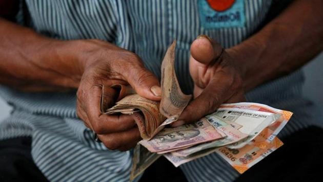 An attendant at a fuel station arranges Indian rupee notes in Kolkata, India, August 16, 2018.(REUTERS)