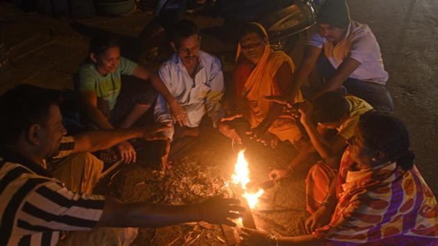 People sit around camp fire on a winter evening in Pune (Pratham Gokhale/HT Photo) People sit around camp fire on a winter evening in Pune (Pratham Gokhale/HT Photo)