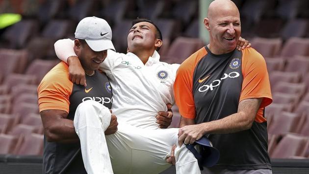 Prithvi Shaw is carried off the ground by support staff after rolling his ankle while attempting a catch during the tour match against Cricket Australia XI in Sydney.(AP)
