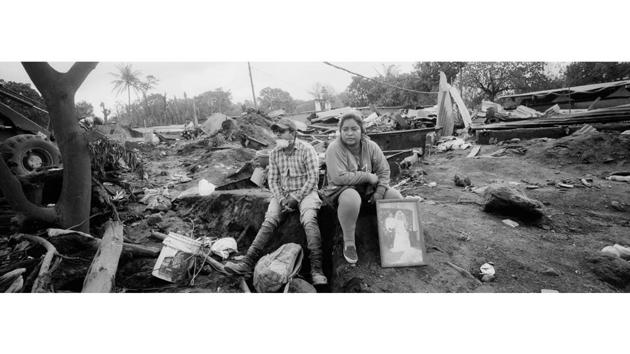 Marlene Vazquez (R), sits next to her cousin Silas Vazquez, with a portrait of their cousins who were killed in the eruption. Outside the morgue, anxious relatives waited for the results of DNA tests to see if their loved ones were among those inside, while others prepared to hold dignified burials in the town cemetery. (Rodrigo Abd / AP) Marlene Vazquez (R), sits next to her cousin Silas Vazquez, with a portrait of their cousins who were killed in the eruption. Outside the morgue, anxious relatives waited for the results of DNA tests to see if their loved ones were among those inside, while others prepared to hold dignified burials in the town cemetery. (Rodrigo Abd / AP)