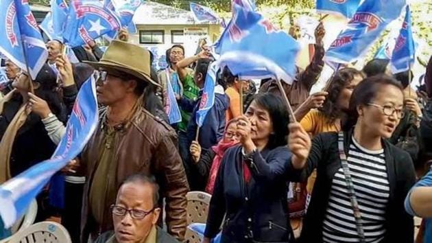 Mizo National Front (MNF) workers hold up party flag as they celebrate the party's victory in the Assembly elections, in Aizawl on December 11.(PTI Photo)