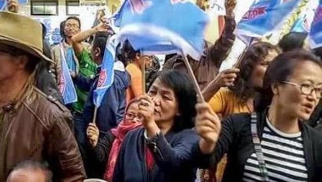 Mizoram assembly election 2018: Mizo National Front (MNF) workers hold up party flag as they celebrate the party's victory in the Assembly elections, in Aizawl.(PTI)