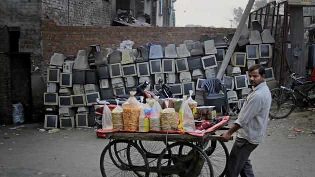 A snack vendor pushes his cart past discarded television sets stacked up on a roadside in New Delhi (Altaf Qadri / AP) A snack vendor pushes his cart past discarded television sets stacked up on a roadside in New Delhi (Altaf Qadri / AP)