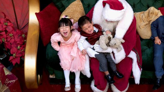 A girl laughs while her brother cries while being held by Santa Claus at the King of Prussia Mall, in Pennsylvania. (Mark Makela / REUTERS) A girl laughs while her brother cries while being held by Santa Claus at the King of Prussia Mall, in Pennsylvania. (Mark Makela / REUTERS)