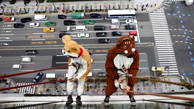 Window cleaners, dressed as a dog (L) and a wild boar, this year and next year’s Chinese zodiac animals, clean the windows of Ryumeikan hotel during a promotional event to celebrate the upcoming new year in Tokyo, Japan. (Kim Kyung-Hoon / REUTERS) Window cleaners, dressed as a dog (L) and a wild boar, this year and next year’s Chinese zodiac animals, clean the windows of Ryumeikan hotel during a promotional event to celebrate the upcoming new year in Tokyo, Japan. (Kim Kyung-Hoon / REUTERS)