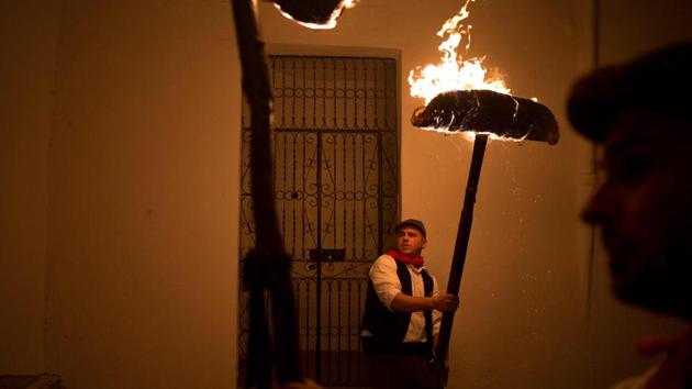 Two men hold their burning ‘rondeles’ (rolled wicker mats soaked in oil) during the Fiesta de los Rondeles, a procession devoted to the virgin of Rondeles, in Casarabonela near Malaga, Spain on the eve of the feast of Santa Lucia. (Jorge Guerrero / AFP) Two men hold their burning ‘rondeles’ (rolled wicker mats soaked in oil) during the Fiesta de los Rondeles, a procession devoted to the virgin of Rondeles, in Casarabonela near Malaga, Spain on the eve of the feast of Santa Lucia. (Jorge Guerrero / AFP)