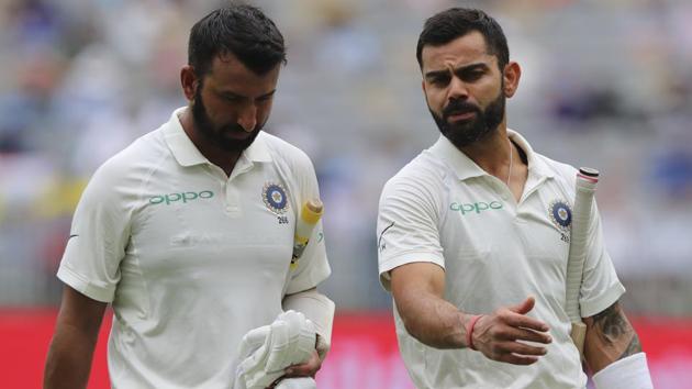 India's Cheteshwar Pujara, left, and Virat Kohli talk as they leave the ground for the tea break. (AP)