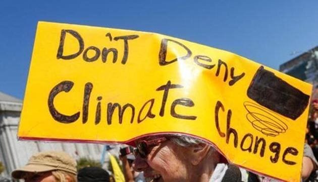 In this file photo taken on September 08, 2018 A woman wears a sign on her head at Civic Center Plaza after marching in the 'Rise For Climate' global action in downtown San Francisco, California. - September 12, 2018, thousands of governors, mayors, CEOs and experts gathered Wednesday at a problem-solving summit to tackle global warming as a monster hurricane bearing the fingerprint of climate change threatens the US eastern seaboard.(AFP)