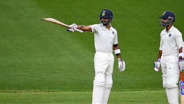 India's batsman Virat Kohli (left) celebrates after scoring his half century in Perth.(AFP)