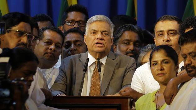 Sri Lanka's reinstated prime minister Ranil Wickeremesinghe, center, surrounded by his loyal lawmakers and supporters speaks after assuming duties in Colombo. (AP Photo) Sri Lanka's reinstated prime minister Ranil Wickeremesinghe, center, surrounded by his loyal lawmakers and supporters speaks after assuming duties in Colombo. (AP Photo)