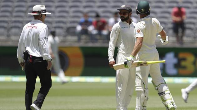India's Virat Kohli, centre, looks to the umpire after he and opposing captain, Australia's Tim Paine came face to face. (AP)