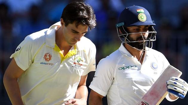 India's captain Virat Kohli (R) runs past Australia's paceman Pat Cummins. (AFP)
