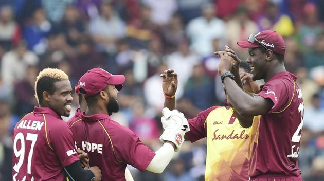 West Indies captain Carlos Brathwaite (right) celebrates with his teammates after the fall of a Bangladeshi wicket.(AFP)