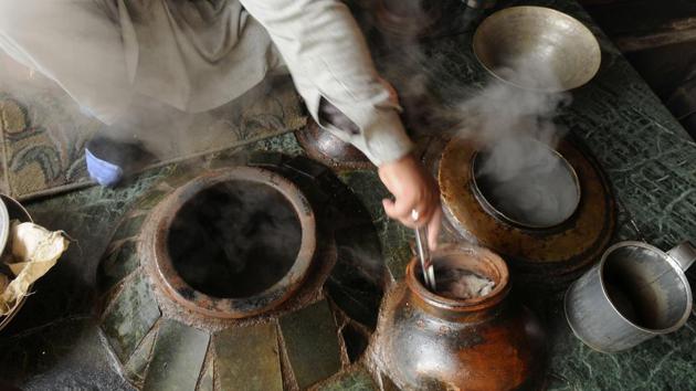 The cooking begins around 10-11pm. In a huge earthen pot, rice gruel is prepared, preferably with the short-grained, sticky Kashmiri kind. In go whole sheep legs, fennel seeds, cinnamon, green and black cardamom, cloves, crispy fried Kashmiri shallots and salt. An hour-and-a-half into cooking, the narrow-necked pot is closed with a lid. This is when Harissa-makers steal a few hours of sleep. (Waseem Andrabi / HT Photo) 