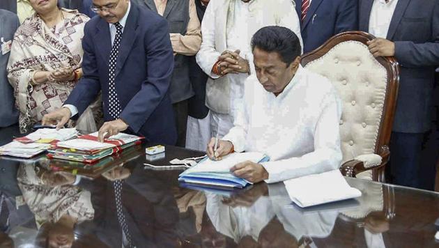 Madhya Pradesh chief minister Kamal Nath signs the farm loan waiver file after assuming office. (PTI) Madhya Pradesh chief minister Kamal Nath signs the farm loan waiver file after assuming office. (PTI)