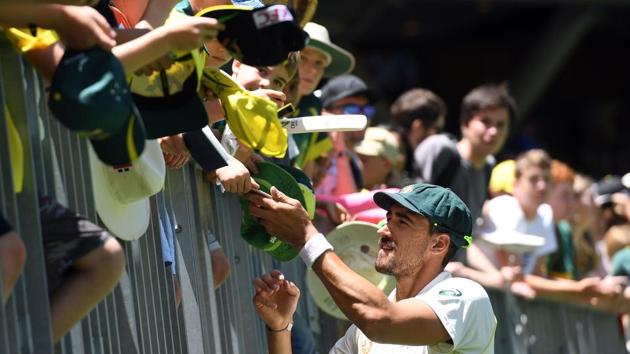 Australia's cricketer Mitchell Starc gives autographs to fans during day five of the second cricket match between Australia and India in Perth. (AFP)