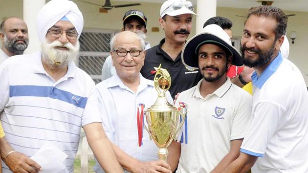 Patiala U 19 team captain Prabhsimran Singh receiving the winning trophy at the DP Azad trophy at Dhruve Pandove Stadium.(HT Photo)