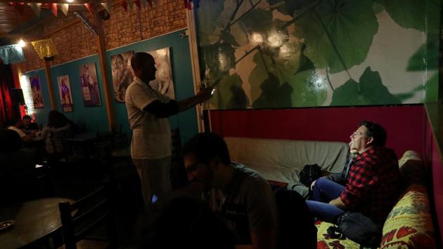 Venezuelan migrant Enrique Miller, 44, takes a picture of customers at a restaurant where mainly migrants work, in Arica. Global attention largely falls on Mediterranean Sea crossings and the Central American caravan. But Chile and other comparatively wealthy Latin American nations are absorbing another wave from destitute nations in the region such as Haiti and Venezuela. (Ivan Alvarado / REUTERS)
