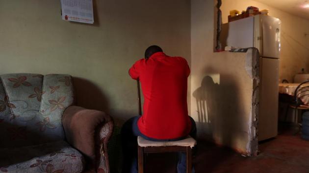 Haitian migrant Stephane, 19, hides his face, posing for a picture at a house in the Cherro Chuno neighbourhood. Guided in many cases by traffickers paid as much as $3,000, police say, the migrants cross in remote areas to avoid border guards, risking a fatal encounter with landmines planted on the frontier decades ago on the orders of former dictator Augusto Pinochet. (Ivan Alvarado / REUTERS)