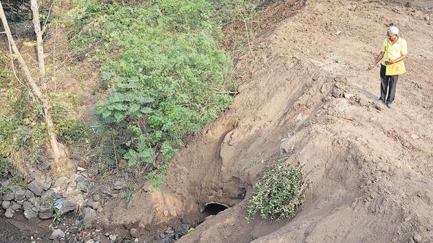 Shailendra Patel, standing on the heaps of rubble,shows the natural spring at Bavdhan Budruk.(Milind Saurkar/HT Photo)