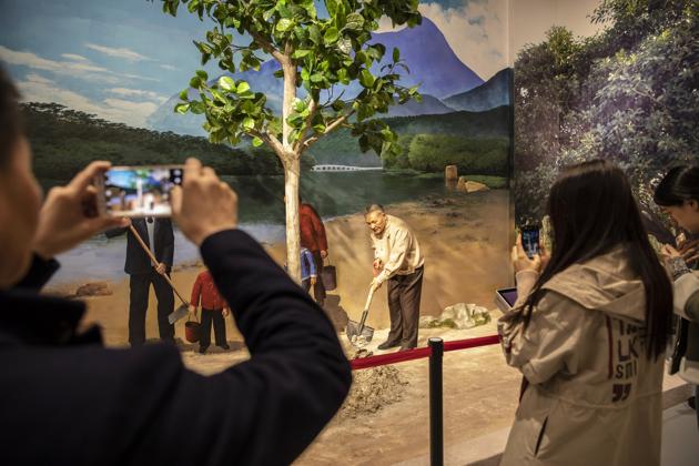 Visitors take photographs of a diorama of China's former leader Deng Xiaoping planting a tree in the "Great Tides Surge Along the Pearl River – 40 Years of Reform and Opening-up in Guangdong" exhibition at the Museum of Contemporary Art & Planning Exhibition (MOCAPE)(Bloomberg)