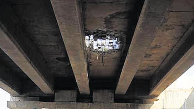 On Monday, a chunk of concrete fell from the flyover at Rampura Chowk in Gurugram, creating a hole on the road.(HT Photo)