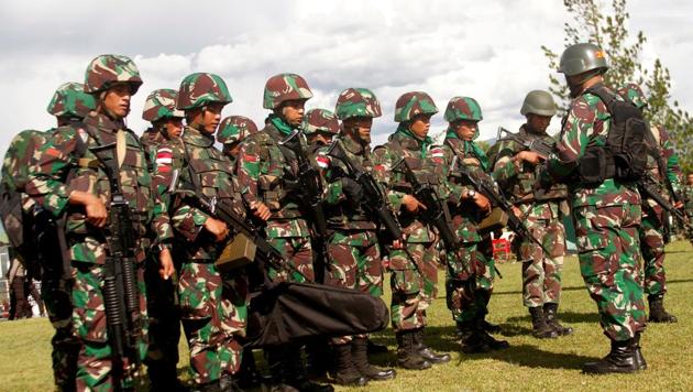 Indonesian soldiers hold rifles as they pray before flying a helicopter to Nduga district in Wamena, Papua province, Indonesia, December 5.(REUTERS)