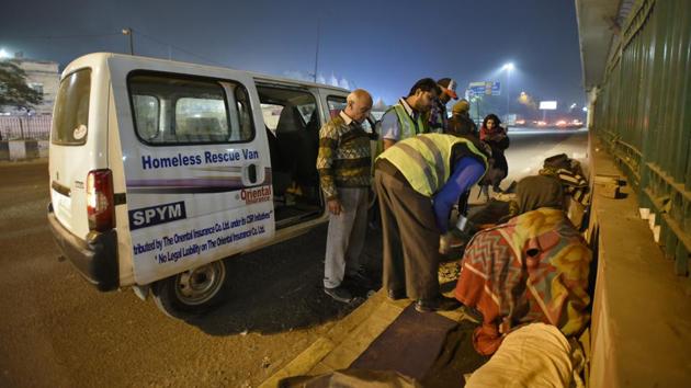 Volunteers try to convince people on a pavement to shift to a shelter home. A project coordinator said that their team moves 10-15 people every day from the streets to the shelters. But there are many who prefer the roadside as they don’t want to give up on public donations. A contractual helper at AIIMS said people come here in the wee hours, give blankets to the first few, click photos and leave. (Burhaan Kinu / HT Photo) Volunteers try to convince people on a pavement to shift to a shelter home. A project coordinator said that their team moves 10-15 people every day from the streets to the shelters. But there are many who prefer the roadside as they don’t want to give up on public donations. A contractual helper at AIIMS said people come here in the wee hours, give blankets to the first few, click photos and leave. (Burhaan Kinu / HT Photo)