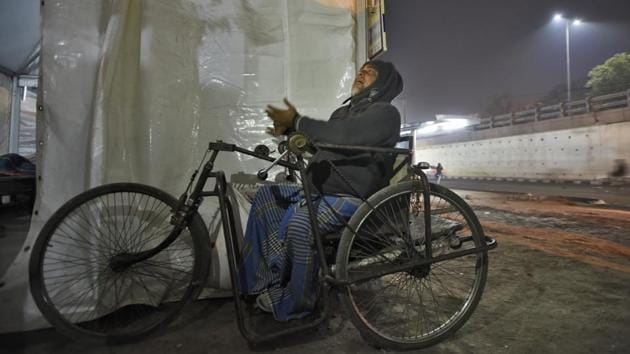 A homeless man outside a temporary shelter. All the shelters are run by NGOs on a contract basis. DUSIB had last year promised warm water, television and breakfast at all its permanent shelters and porta cabins. But geysers, though one each to cater to around 150-200 people, were functional and breakfast was provided only at a few shelters. (Burhaan Kinu / HT Photo) A homeless man outside a temporary shelter. All the shelters are run by NGOs on a contract basis. DUSIB had last year promised warm water, television and breakfast at all its permanent shelters and porta cabins. But geysers, though one each to cater to around 150-200 people, were functional and breakfast was provided only at a few shelters. (Burhaan Kinu / HT Photo)