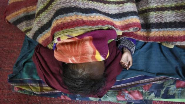 A homeless man sleeps next to his child inside a shelter home, at Nizamuddin Basti. Sunil Kumar Aledia, executive director Centre for Holistic Development, said the facilities are far better this year but around 300-400 people outside AIIMS are still out in the open. (Burhaan Kinu / HT Photo) A homeless man sleeps next to his child inside a shelter home, at Nizamuddin Basti. Sunil Kumar Aledia, executive director Centre for Holistic Development, said the facilities are far better this year but around 300-400 people outside AIIMS are still out in the open. (Burhaan Kinu / HT Photo)