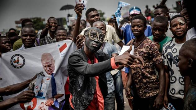 Supporters of opposition leader Martin Fayulu sing and dance as they march and chant slogans in the streets of the Ndjili district of Kinshasa, ahead of a campaign rally for Democratic Republic of Congo’s general elections. (Luis Tato / AFP) 